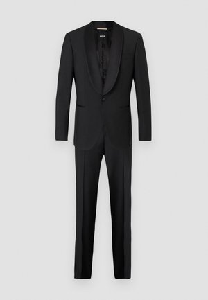 Completo elegante nero con rever in satin, chiusura a un bottone e pantaloni a tartan. Texture liscia, design slim fit.