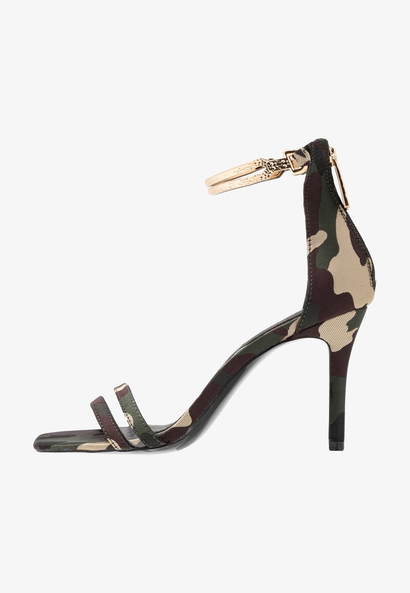 Sandale à talon haut pour femme avec un motif camouflage vert et marron, deux brides à l'avant et une bride à la cheville avec une boucle dorée.