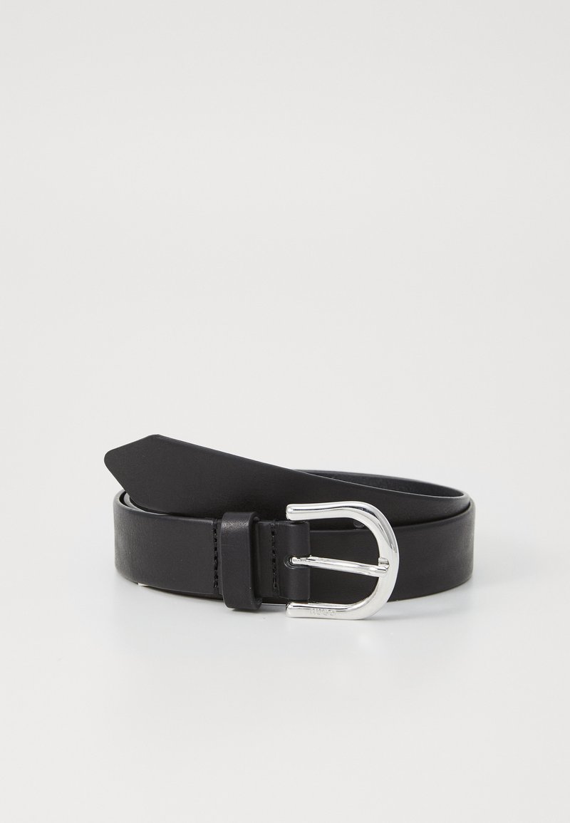 Černý kožený pásek s zaoblenou sponou ze stříbrného tónu, plochým designem pásu a jedním kroužkem pro přizpůsobení.
