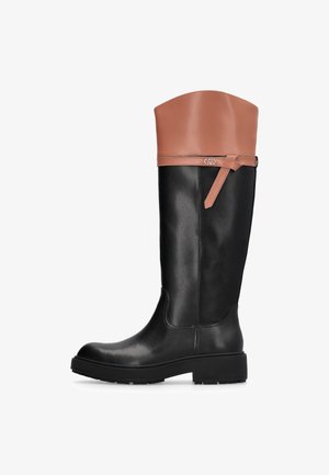 Botte noire en cuir montée jusqu'au genou avec une manche en cuir beige. Présente un détail de sangle sur le côté et une tige texturée avec une semelle robuste en caoutchouc noir.