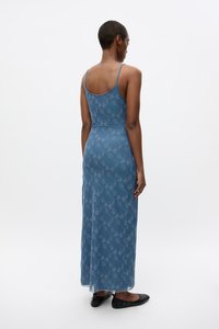 Blue maxi dress with spaghetti straps, featuring a floral pattern in a lighter shade. Made from a smooth, lightweight material.