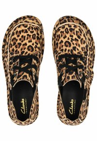 Zapatos de estampado de leopardo con una textura suave, cordones negros y una forma redondeada, con un interior acolchado negro y el logo de la marca.