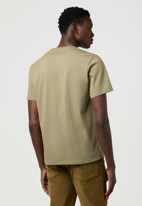 Wrangler SHORT SLEEVE SMALL GRAPHIC TEE - REGULAR FIT - Camiseta estampada - aloe