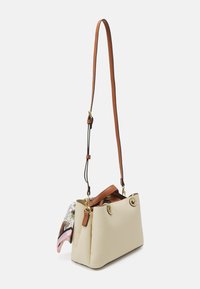 Borsa a tracolla in finta pelle beige con una forma strutturata, dettagli marroni, metalleria dorata e una sciarpa decorata staccabile attaccata al lato.