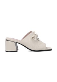 Crème open-toe mules met een gestructureerde bovenkant, strikdetail en een blokhak met een metallic accent. De zool is zwart met een gladde afwerking.