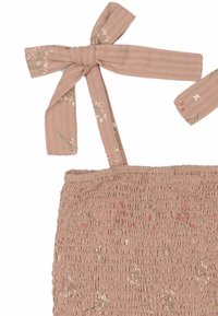 Smockana bluza iz svetlo bež pamuka s cvetnim printom. Ima nastavljive trakice u obliku mašne i teksturiranu površinu s uvučenim detaljima.