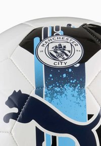Hvid fodbold med et blåt og sort design, Manchester City-logo, samt en blå gradient med en sort katte-silhuet.