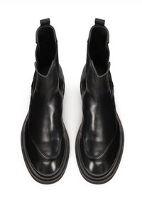 Botas de cuero negro hasta el tobillo con textura lisa, diseño sin cordones con lados elásticos y una tira en la parte posterior. Punta redonda y suela gruesa.