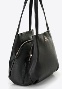 Borsa tote in pelle nera con due tasche con zip, superficie texturizzata, manici lunghi e un accento in logo dorato su un lato.