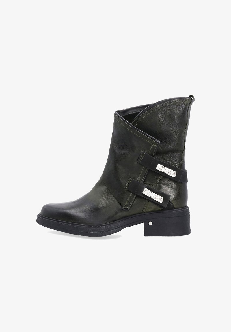Zielona skórzana botka sięgająca kostki z asymetrycznym wykończeniem, czarnymi akcentami i metalowymi klamrami. Posiada masywny obcas i teksturowaną powierzchnię.
