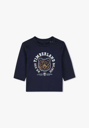 Navy blauwe lange mouwen peuter shirt met berenafbeelding en Timberland logo tekst op de voorkant, drukknoopjes op de schouders voor makkelijk aan- en uittrekken.