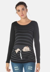 Schwarzes langärmliges Shirt mit horizontalen Streifen und einem Grafikdesign eines Cartoon-Babys, das durch einen Ausschnitt schaut. Hergestellt aus weichem Stoff mit einem runden Halsausschnitt.