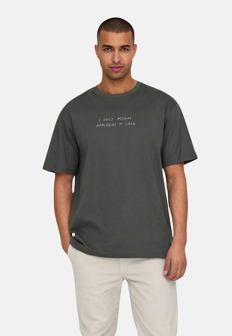 Dark gray cotton t-shirt with short sleeves, a round neckline, and white text that reads, "I ONLY ACCEPT APOLOGIES IN CASH."