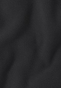 Zwart textiel met zichtbare zachte fleecevezels en subtiele plooi-kreukels die een gezellige, warme uitstraling creëren.