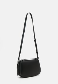 Sac en cuir noir à bandoulière avec une texture lisse, une forme arrondie, une sangle réglable et des accents en métal argenté. Pas de motifs ou de logos visibles.