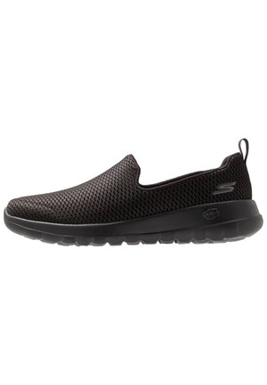 Sort slip-on sneaker med åndbart mesh-overdel, tyk polstret sål og trækkrog ved hælen, vist i profil på hvid baggrund.