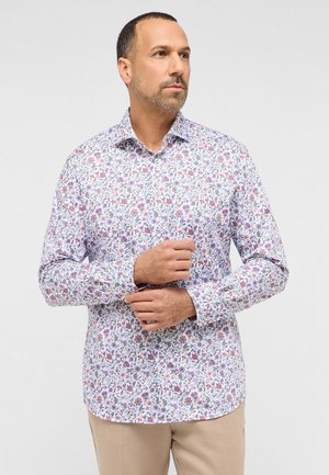 Camicia bianca a maniche lunghe con stampa floreale in viola e rosa, polsini abbottonati e colletto a punta. Tessuto liscio.