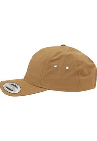 Barna baseball sapka puha anyagból, strukturált korona és ívelt sínekkel. Két szellőzőlyukkal és egy kerek márkajelzéssel rendelkezik az elején.