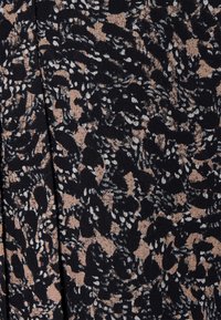 Tecido preto com um padrão abstrato em bege e branco, apresentando formas onduladas e pequenos pontos, transmitindo uma aparência texturizada.