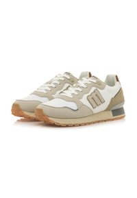 Zapatillas de deporte beige claro con acentos blancos, materiales de ante y malla, punta redonda, suela de goma texturizada y logo distintivo en el lateral.