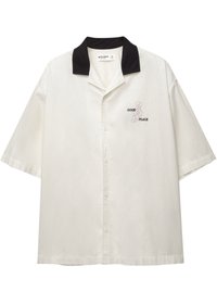 Krátky rukáv košele na gombíky z off-white látky s čiernym golierom. Obsahuje vyšívaný text "DOBRÉ MIESTO" v purpurovej a čiernej farbe.