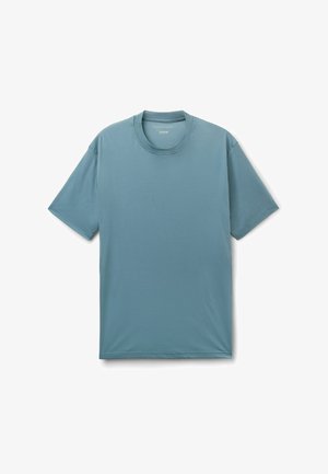 Gładki, stonowany niebieski t-shirt z krótkim rękawem i okrągłym dekoltem, rozłożony na białym tle.