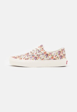 Witte lage Vans sneaker met vetersluiting en veelkleurige kleine bloemenprint in paarse, roze en oranje tinten.