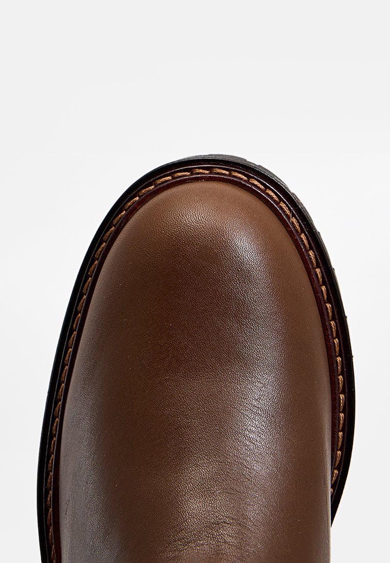 Braune Lederschuhe mit runder Zehenform, glatter Oberfläche, Kontrastnähten und einer dunklen Gumm sole. Minimalistisches Design, hochwertige Materialien.