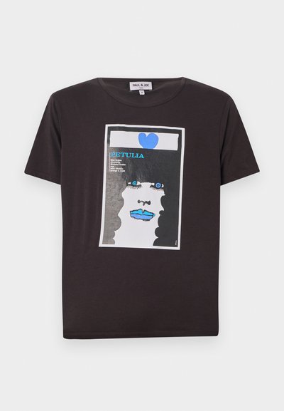 Musthave musta puuvillane t-särk, millel on graafiline kujundus naise näost, millel on sinised huuled, suured sinised silmad ja süda, raamitud valgesse ristkülikusse.