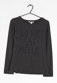 T-shirt noir à manches longues avec col rond ; présente une impression texturée avec l'inscription "LA VIE EST BELLE" en fil sombre ; tissu doux.
