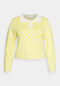Pullover amarelo de malha com padrão de corações brancos, apresentando um colarinho branco e mangas compridas. Design cropped com fecho em botão.