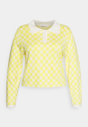 Pullover amarelo de malha com padrão de corações brancos, apresentando um colarinho branco e mangas compridas. Design cropped com fecho em botão.