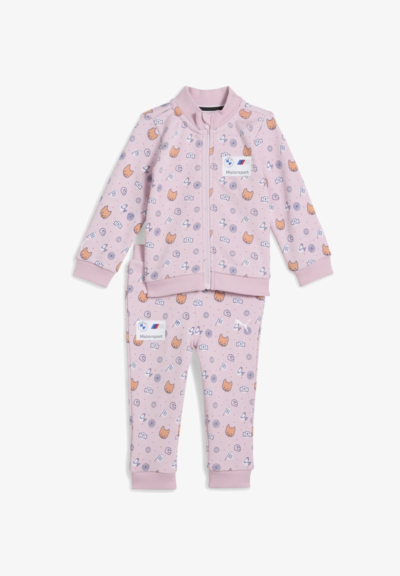 Svetlo roza otroški trenirki iz mehkega materiala, okrašena z motivom mačk in igrivih ikon, z jopico na zadrgo in elastičnimi manšetami.