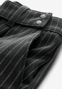 Schwarze Nadelstreifen-Hosen aus glattem Stoff, mit zwei schwarzen Knöpfen am Bund und einem strukturierten Bunddesign.