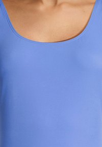 Bañador sin mangas azul con cuello redondo, hecho de un material suave, que presenta una textura similar a la de la piel y detalles de costura mínimos.