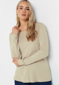 Maglietta beige a maniche lunghe con scollatura tonda e texture morbida. Design semplice con vestibilità comoda e dettagli di cucitura discreti.