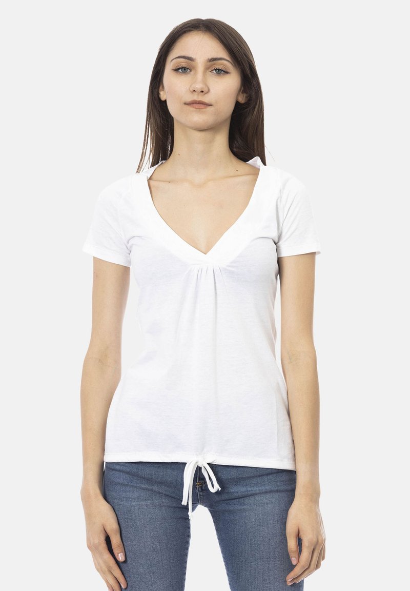T-shirt bianco a maniche corte con scollatura a V profonda e dettaglio arricciato al centro. Il tessuto appare morbido con una leggera texture; dettaglio dell'orlo annodato.
