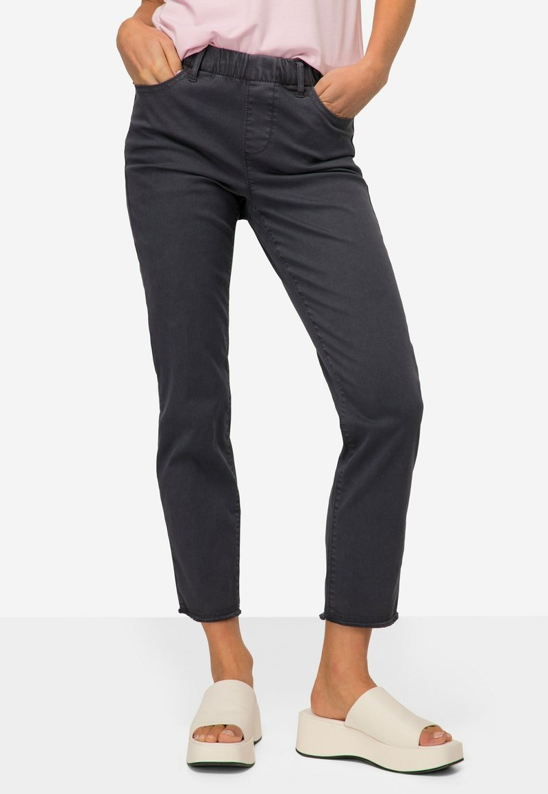Grijze, taps toelopende jeans met een elastische tailleband en zijzakken. Gemaakt in combinatie met witte platform sandalen. Glad texture en casual ontwerp.