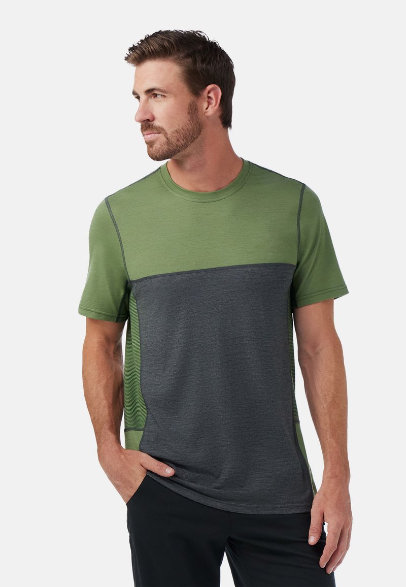 Kortärmad sporttröja med en grön överdel och en mörkgrå underdel, med en mjuk yta och subtila sömnadsdetaljer.