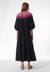 Robe maxi noire avec des manches bouffantes et un col en dentelle violette détaillé avec un motif à carreaux. Tissu lisse, design longueur cheville.