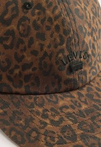 Brown and black leopard print baseball cap with black embroidered "Levi's" logo on front panel.