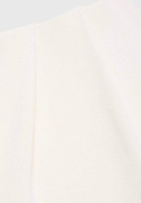 Tessuto color crema con una superficie texturizzata e una leggera lucentezza, caratterizzato da pieghe per aggiungere dettaglio e interesse visivo.