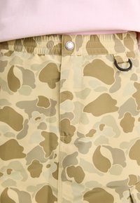 Camouflage shorts in lichtbeige met groene en grijze vlekken. Voorzien van een elastische tailleband, knoopsluiting en een zijlus.