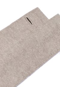Beige knitted fingerless gloves with thumb hole, made of soft yarn for warmth and comfort, laid flat on white background.