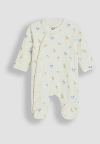Un onesie à manches longues de couleur jaune clair, avec des motifs floraux bleus et jaunes, des fermetures à pression et un bord festonné sur le devant.