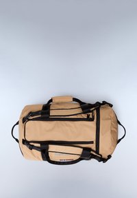 Beige duffel bag made of durable fabric, featuring black accents, multiple zippered pockets, and padded handles for comfortable carrying.
