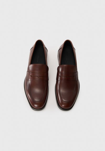 Bruna läderloafers med en slät yta, mandelformad tå och dekorativ sömnad på vampen. Gummisula för bra grepp.
