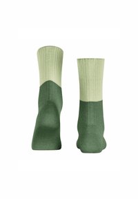 Zielone i jasnozielone skarpetki prążkowane z efektem dip-dye. Wykonane z gładkiego materiału, o średniej długości i dopasowanym kształcie.