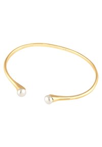 Armbandet i guldton med en slät, böjd design. Har runda vita pärlor i varje ände. Minimalistiskt och elegant utseende.