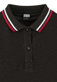 Black polo shirt with a ribbed collar featuring red, white, and black stripes. Two-button placket and textured fabric. Brand label visible.